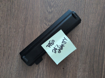 Photo of the old battery, a black piece of plastic on a brown wooden floor. There’s a Post-it note attached saying “T480 24% capacity”